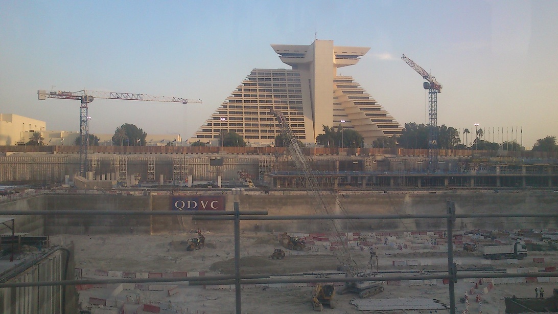 Hotelbaustelle mit markanter Pyramidenarchitektur im Hintergrund, die innovative und nachhaltige Baukonzepte andeutet.